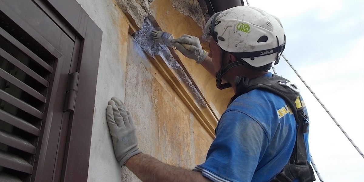ouvrier acrobatie lors de la rénovation d'une façade
